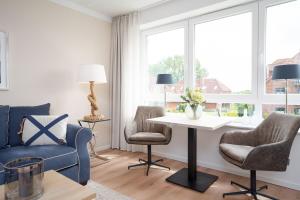 a living room with a blue couch and chairs and a table at Hauptstraße 26e Deck 9 in Timmendorfer Strand