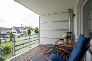a balcony with a wooden table and chairs at Hauptstraße 26e Deck 9 in Timmendorfer Strand