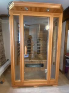 a wooden cabinet with a glass door in a room at Gîte de la source in Sainte-Marie-de-Vaux