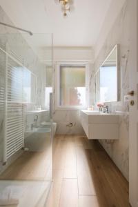 un bagno bianco con 2 lavandini e una doccia di Sant'Orsola Lodge Bologna a Bologna Altre 37 foto