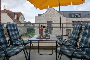 een tafel en stoelen met een vaas met bloemen op een balkon bij Wohnresidenz Wohnung 2 in Kellenhusen