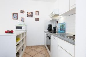 een keuken met witte kasten en een aanrechtblad bij Wohnresidenz Wohnung 2 in Kellenhusen