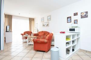 een woonkamer met een stoel en een tafel bij Wohnresidenz Wohnung 2 in Kellenhusen