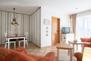 een woonkamer met een bank en een tafel bij Wohnresidenz Wohnung 2 in Kellenhusen +9 foto's
