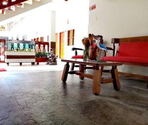 a living room with a red couch and a table at Hotel Diamante in Saravena