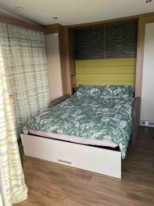 a bedroom with a bed with a green comforter at The View in Ballantrae +17 photos