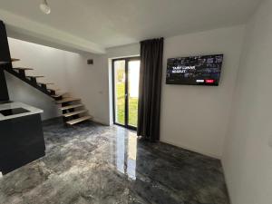 a living room with a staircase and a window at Zen Residence in Curtea de Argeş