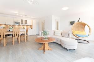 Una sala de estar con un sofá blanco y una mesa. en Haus Seeblick Bosau Seeadler, en Bosau