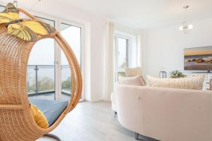 Una sala de estar con una silla de mimbre y un sofá blanco. en Haus Seeblick Bosau Seeadler, en Bosau 34 fotos más