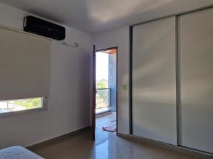 Habitación con puerta corredera de cristal y ventana en TORRES ZONA Casa de Gobierno, en Santiago del Estero