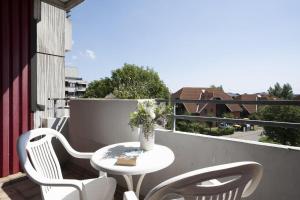 a table and two chairs on a balcony with a table and flowers at Berolina Ostseegold in Dahme