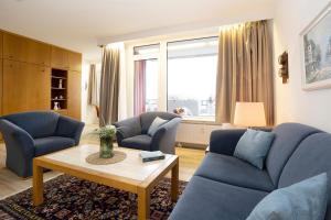 a living room with two blue couches and a table at Berolina Ostseegold in Dahme