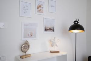 a room with a table with a lamp and pictures on the wall at Pier 67 Kleine Muschel in Roge +18 photos