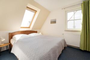 a bedroom with a white bed and two windows at Vadersdorf VIc in Vadersdorf