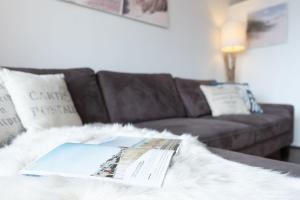 a living room with a couch and a book on a table at Berolina Badebude 214 in Dahme