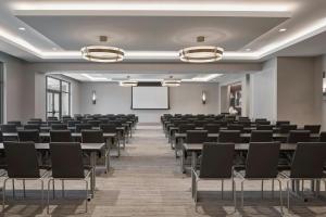 a conference room with tables and chairs and a whiteboard at AC Hotel Savannah Historic District in Savannah