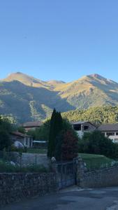 a house with a fence and mountains in the background at Benasque Valley Apartment in Bisaurri