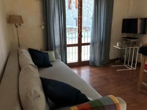 a living room with a couch and a large window at Benasque Valley Apartment in Bisaurri