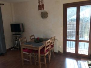 a dining room with a table and chairs and a television at Benasque Valley Apartment in Bisaurri