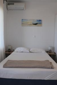a white bed with a blanket on top of it at Ateni House Garden in Agios Petros