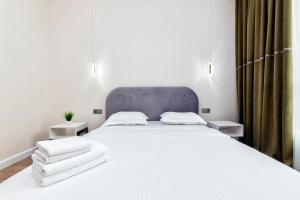 TaldykolʼにあるRaisson Ahotel Headliner E39-Khan Shatyrのタオルが敷かれた大きな白いベッドのある寝室