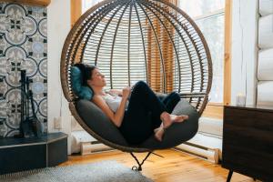 een vrouw in een rieten stoel in een kamer bij Be zen with nature & enjoy private hot tub in Lac-Superieur +36 foto's