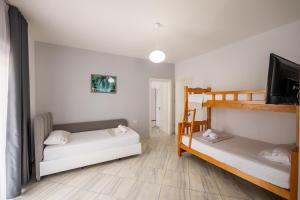 a bedroom with two bunk beds and a flat screen tv at Hotel Artur2 in Ksamil
