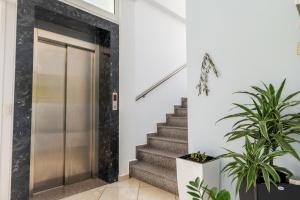 a hallway with stairs and a metal elevator at Hotel Artur2 in Ksamil