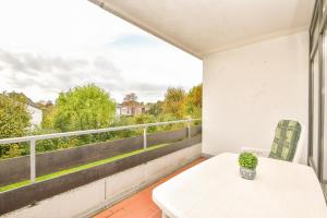 a balcony with a white table and a view of trees at Schützenweg 6 Ostseesonne in Kellenhusen