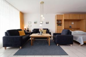 a living room with two chairs and a table and a bed at Schützenweg 6 Ostseesonne in Kellenhusen