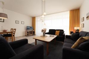a living room with two couches and a table at Schützenweg 6 Ostseesonne in Kellenhusen