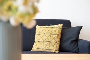 a blue couch with aige and black pillow on it at Schützenweg 6 Ostseesonne in Kellenhusen