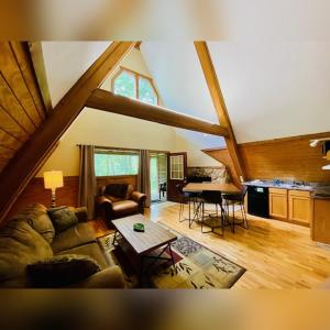 a living room with a couch and a table at A-Frame #04 - by The Chalets in Logan