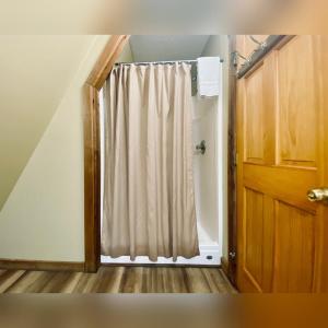 a shower door with a curtain in a room at A-Frame #05 - by The Chalets in Logan +7 photos