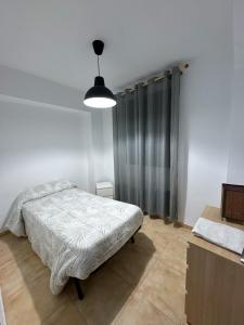 Dormitorio blanco con cama y lámpara en APT en centro fútbol 1min Playa 10min, en Villareal