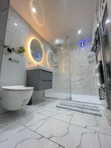 a white bathroom with a shower and a toilet at Peaceful 3 bedrooms house to rent in East London in Dagenham