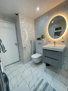 a bathroom with a toilet and a sink and a mirror at Peaceful 3 bedrooms house to rent in East London in Dagenham +21 photos