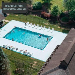 an overhead view of a swimming pool with people in it at A-Frame #06 - by The Chalets in Logan