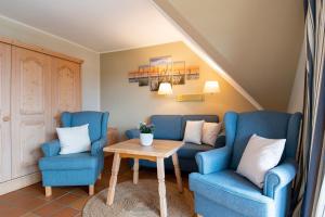 a living room with blue chairs and a table at Landhaus Pönitz am See Wohnung 11 in Klingberg