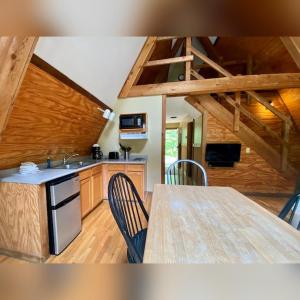 a kitchen with a table and chairs in a room at A-Frame #06 - by The Chalets in Logan