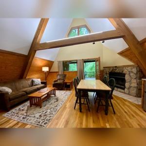 a living room with a table and a fireplace at A-Frame #07 - by The Chalets in Logan