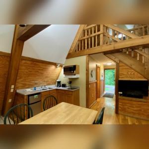 a kitchen and dining room with a table in a house at A-Frame #07 - by The Chalets in Logan +12 photos