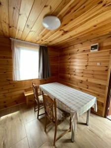 a dining room with a table and chairs in a cabin at Ośrodek Szeligi in Ełk