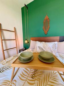 a table with two green plates on top of a bed at Private Suite with Terrace & Jacuzzi in Mérida