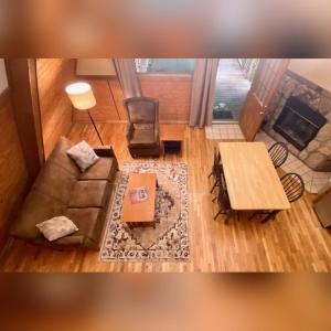 a living room with a couch and a table at A-Frame #07 - by The Chalets in Logan +12 photos