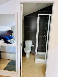 łazienka z toaletą i łóżkiem w obiekcie Fogar das Pupieiriñas w mieście Corcubión