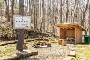a sign for a chates fire pit in the woods at A-Frame #08 - by The Chalets in Logan