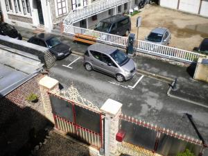 a car parked in a parking lot next to a building at Chambre D'hôte Villa Maurice in Étretat