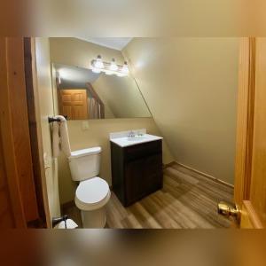 a small bathroom with a toilet and a sink at A-Frame #08 - by The Chalets in Logan +13 photos
