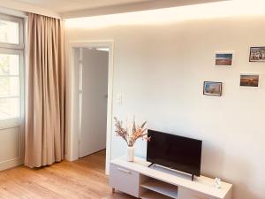 a living room with a flat screen tv on a white table at Sopot Modern Apartments 3 in Sopot